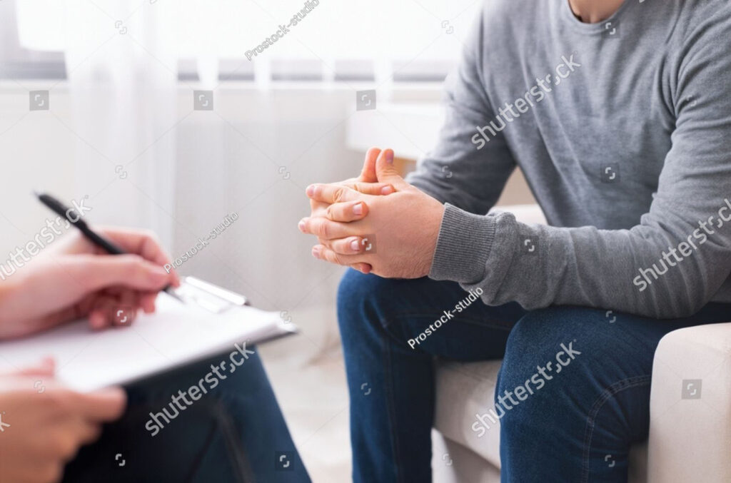 stock-photo-therapist-writing-notes-during-counseling-session-with-single-man-sitting-on-couch-panorama-empty-2459475609